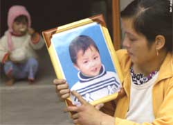  Mother holds portrait of her deceased son 