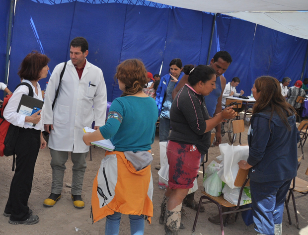 La representante de la OPS/OMS en Chile, Paloma Cuchi, conversa con miembros de la brigada médica cubana que brindan atención a personas