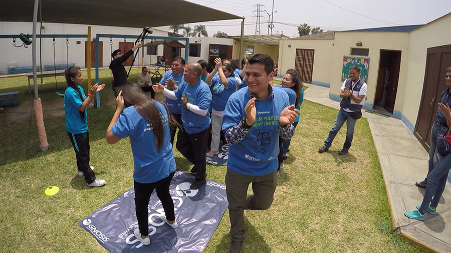 Familias y entrenadores bailando durante el programa de Familias Fuertes en Perú.